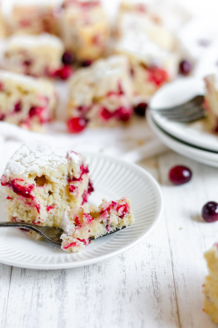 Image shows a plate of cranberry kuchen with a fork