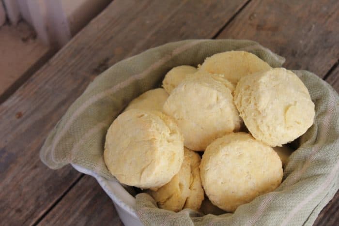 Image shows a basket of biscuits on a wooden table 