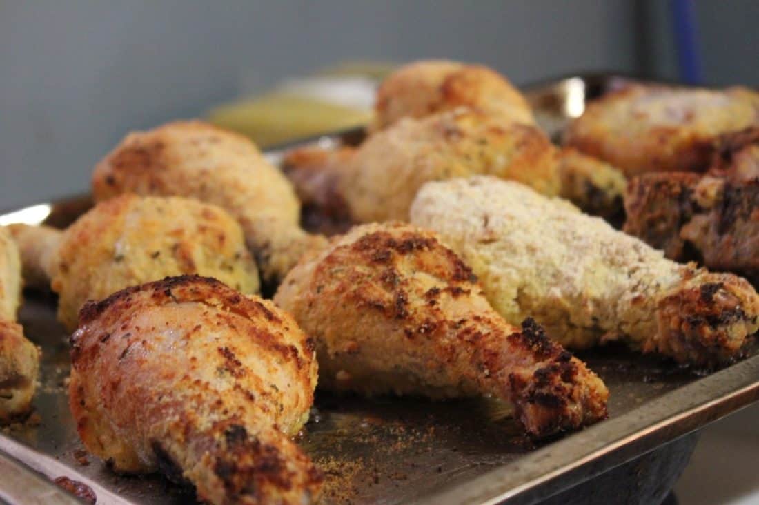 Image shows a cookie sheet with gluten-free fried chicken legs.