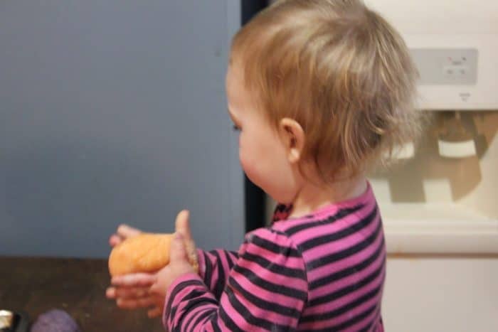 Image shows a small child playing with playdough