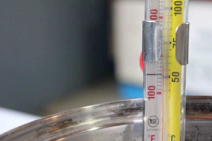 A thermometer displays a reading in a metal bowl