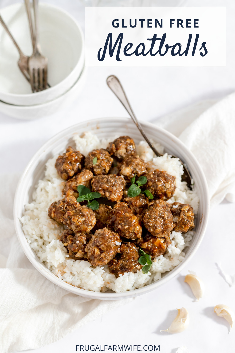 Photo shows a white bowl full of rice, with gluten free meatballs on top and a fork sticking out. Behind sits a bowl with more forks, text overlay reads "Gluten Free Meatballs"