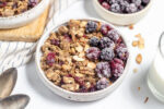 bowl of homemade healthy granola cereal with berries and milk