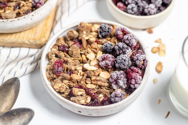 bowl of homemade healthy granola cereal with berries and milk