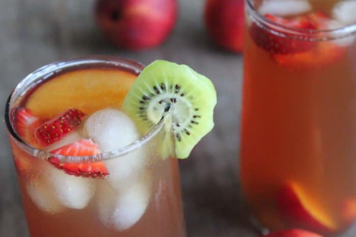 Photo shows two glasses of iced tea with fruit as garnishes