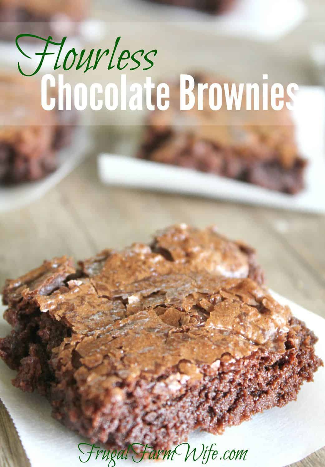 Image shows a close up of a gluten-free flourless chocolate brownie on a white plate. Text overlay reads "Flourless Chocolate Brownies"