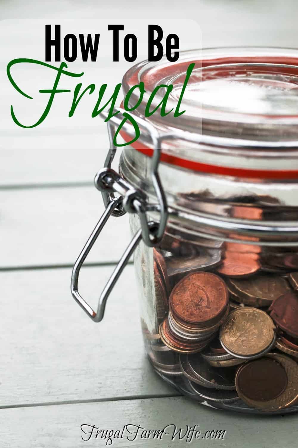 Image shows a close up of a small mason jar filled with coins. Text overlay reads "How to be Frugal"