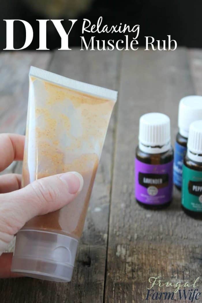 Photo shows a hand holding a bottle of muscle rub next to small bottles of essential oils