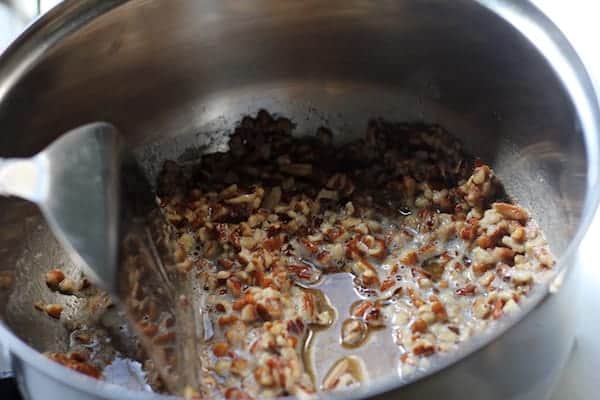 Image shows a pot of pecans simmering
