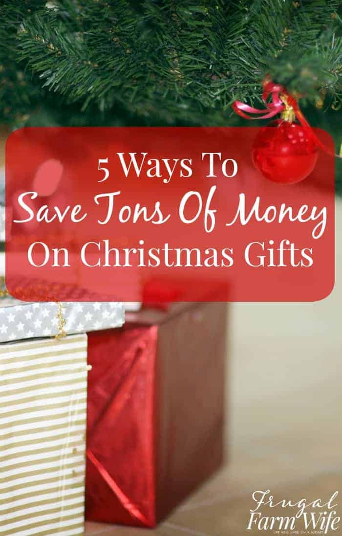 Image shows a close up of a Christmas tree with gifts beneath it. Text overlay reads "5 Ways to Save Tons of Money on Christmas Gifts"