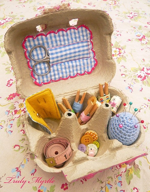Image shows a small egg carton made into a sewing kit container