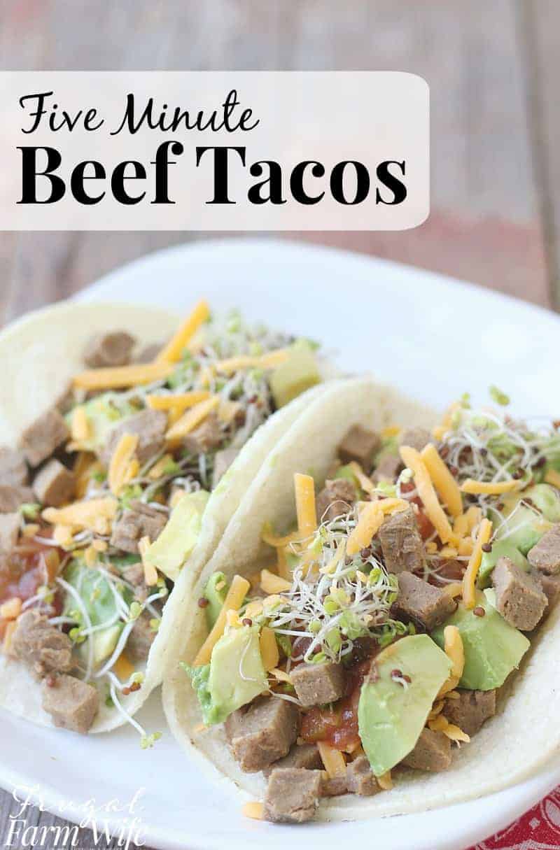 Image shows a close up of two soft taco shells full of beef, cheese, avocado, salsa, and bean sprouts. Text above reads "Five minute beef tacos"