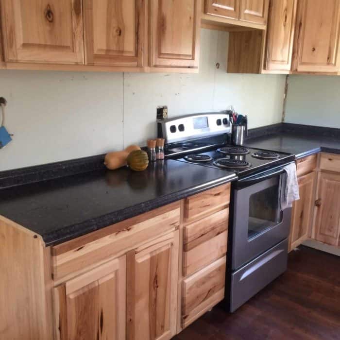 Photo shows the new kitchen inside the mobile home, with dark counters and with wood cabinets