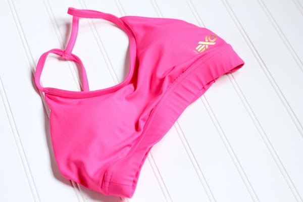 Image shows a bright pink sports bra laid out on a white table 