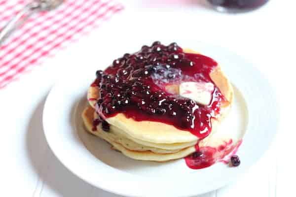 Image shows blueberry syrup on homemade pancakes