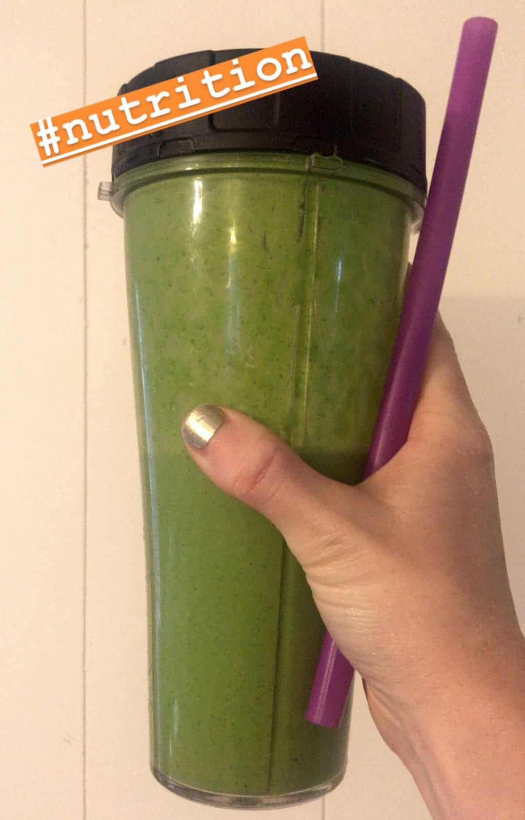 Image shows a hand holding a large container with a green smoothie in it. Text reads "#nutrition"