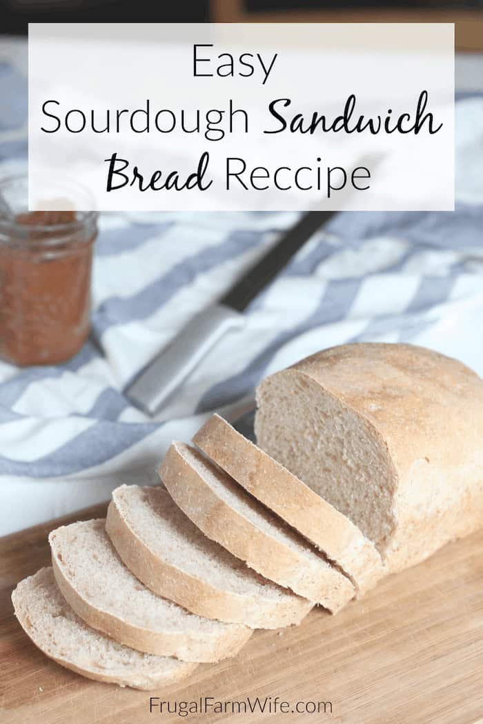 Image shows a loaf of sour dough bread sliced on a cutting board. Copy reads "Easy Sourdough Sandwich Bread Recipe"