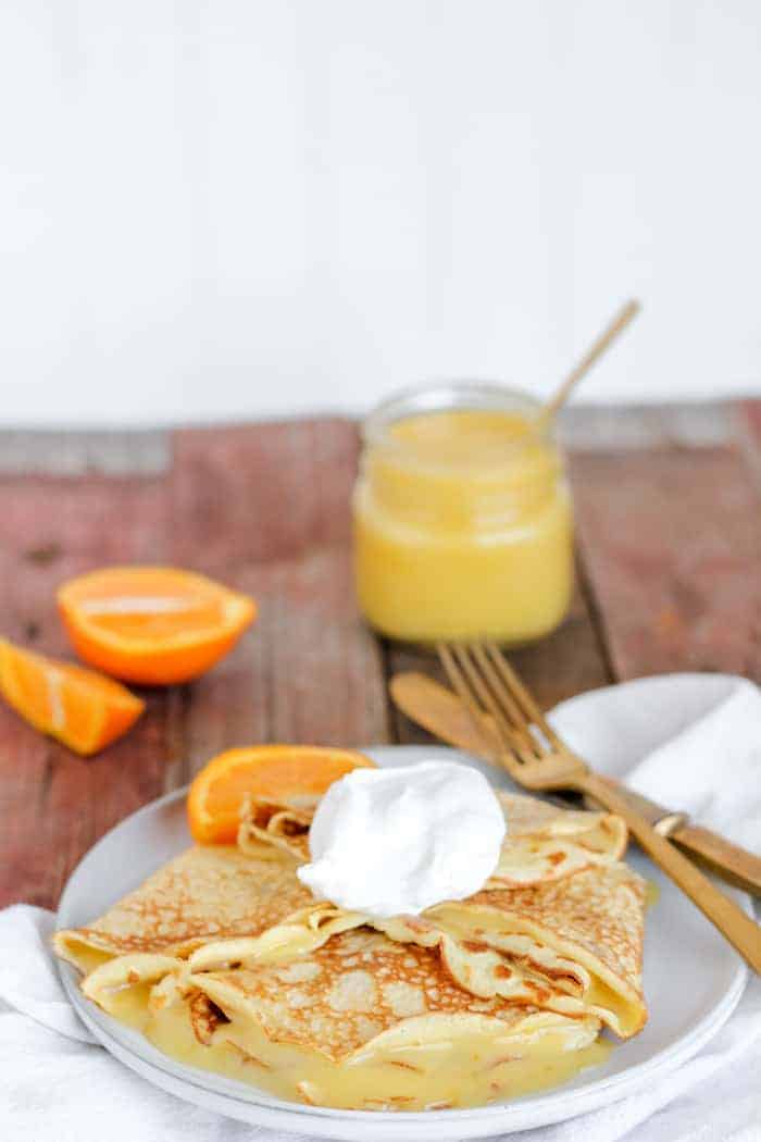 Photo shows a plate of crepes, with a scoop of homemade orange curd on top