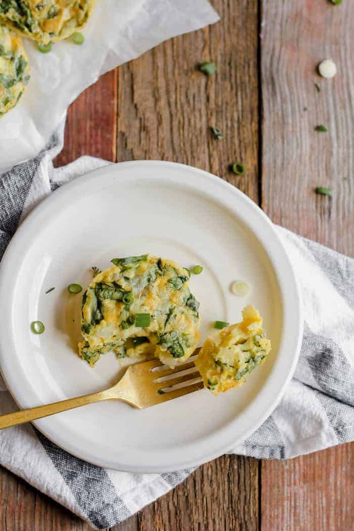 Photo shows a small vegetable egg bite on a white plate