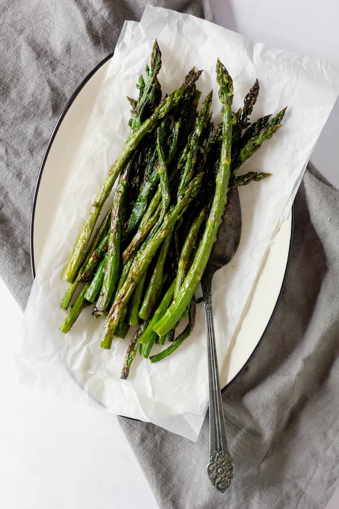 Image shows a plate of oven roasted asparagus