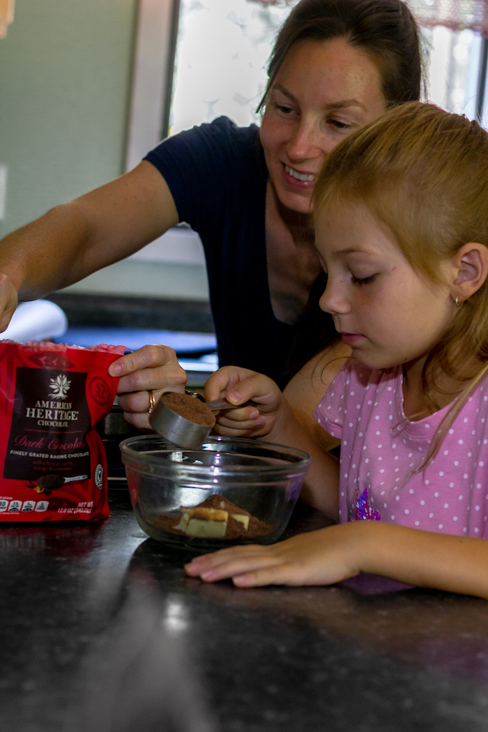 Image shows a woman and young girl pouring cocoa into a bowl