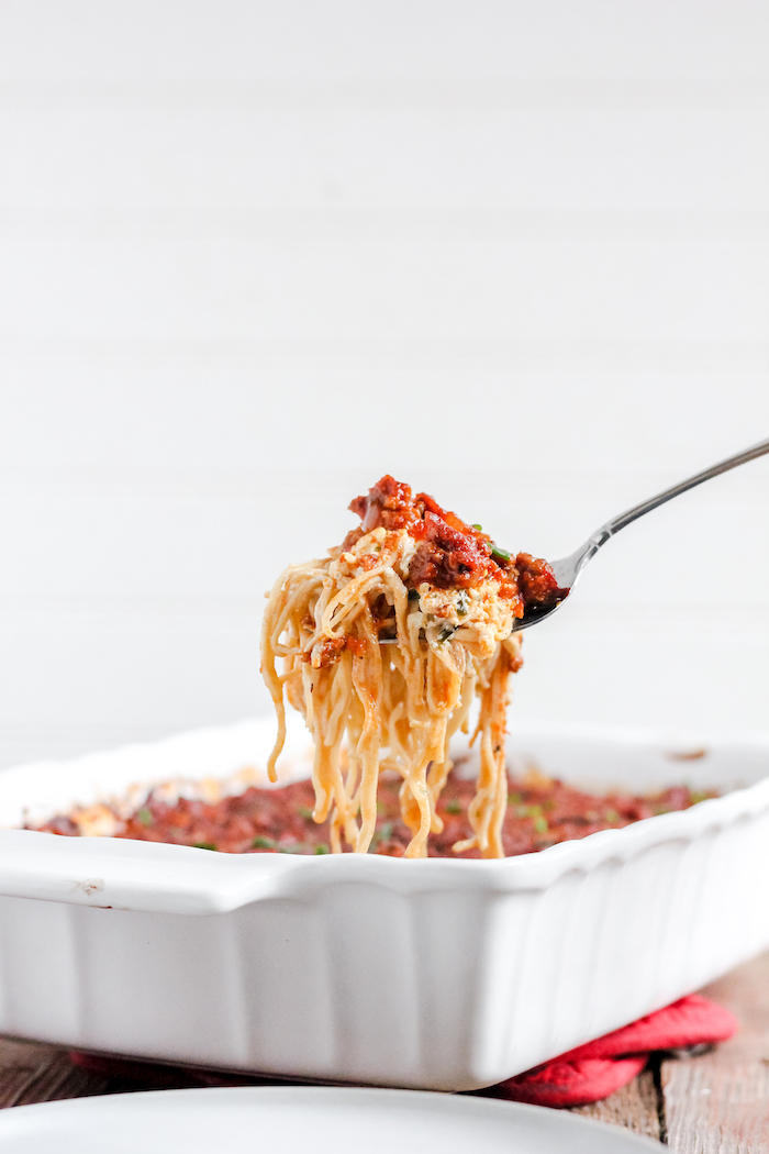 Image shows a forkful of spaghetti over a casserole dish