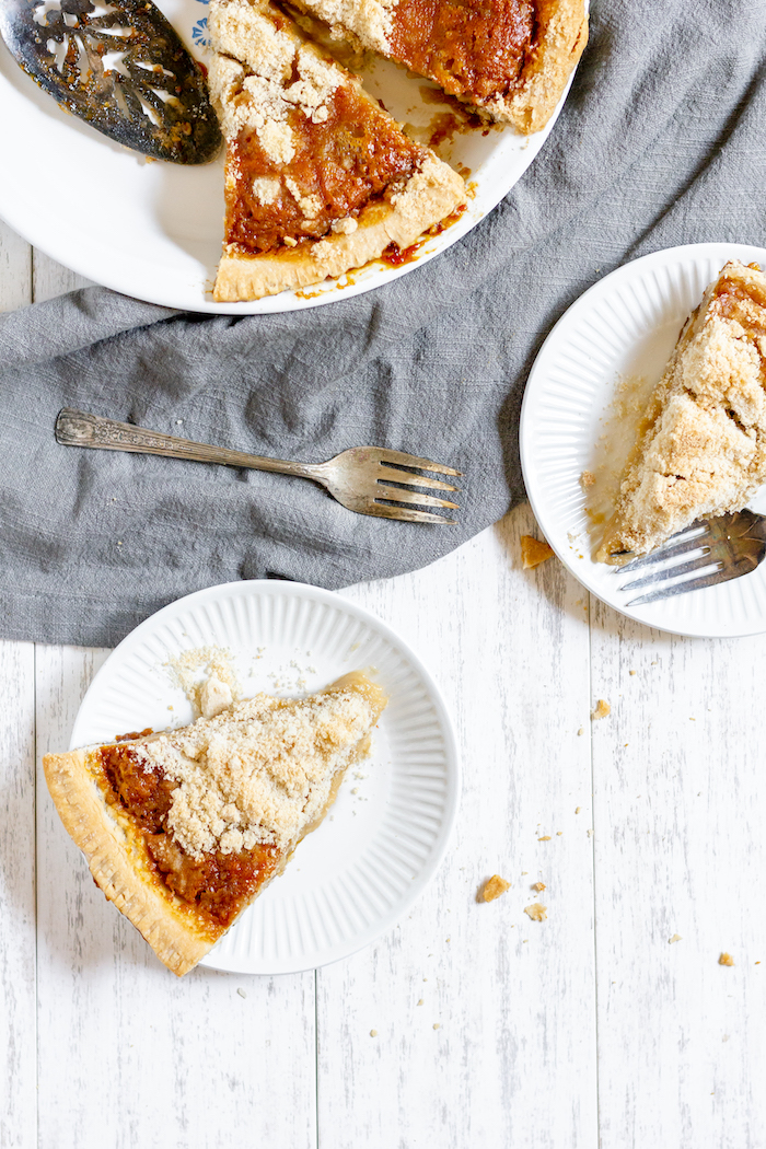 Photo shows two plates with pieces of pie, next to a pie tin with the rest of the pie, photographed from above