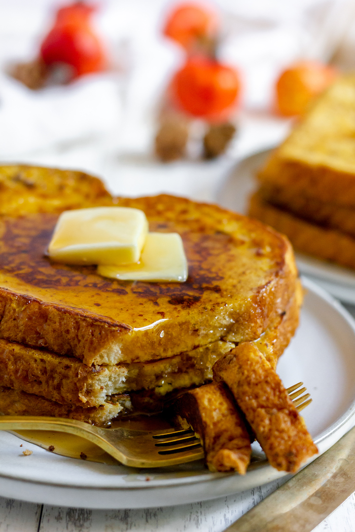 Image shows a close up of a plate of French Toast with butter and syrup