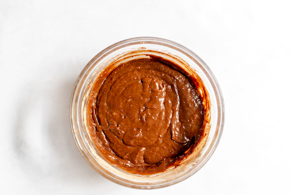 Image, taken from above, shows a glass bowl with the mixed brownie bite batter