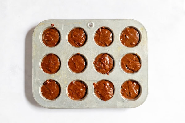 Image, taken from above, shows the brownie batter in a mini muffin pan