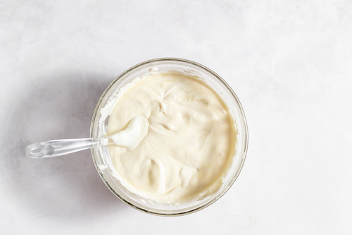 Image, taken from above, shows a glass bowl with all the ice cream ingredients mixed together. 