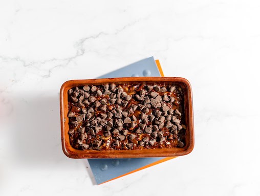 Image shows a bread pan with chocolate zucchini bread, gluten free, ready to bake