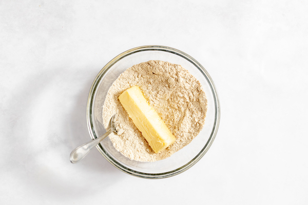 Butter sitting on top of a flour and sugar mixture before combining.