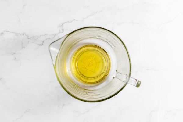 Image shows a glass mixing cup with oil in it ready to mix with the other ingredients