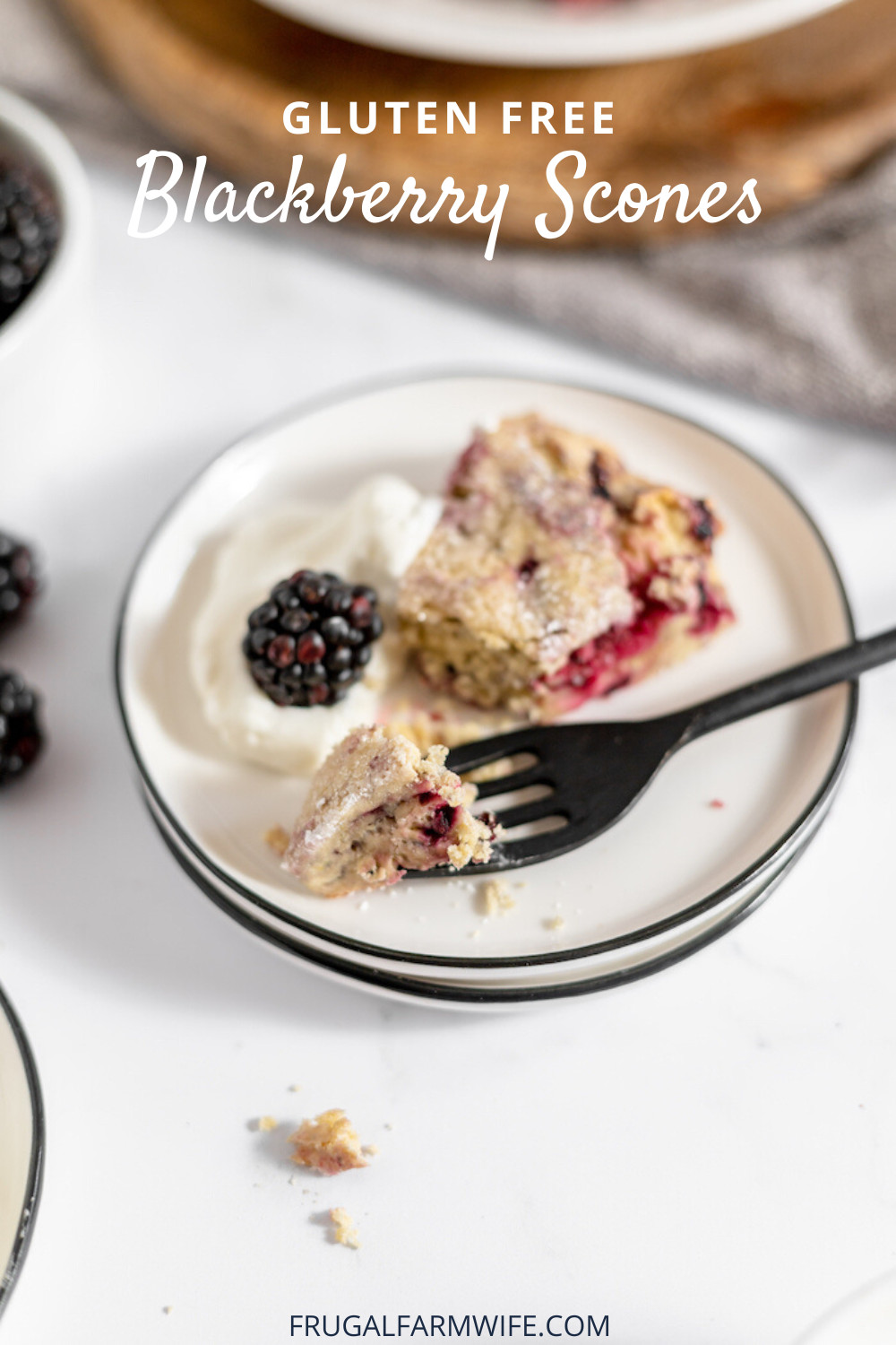 Image shows a small white plate with black trim with a gluten free blackberry scone sitting on it with a fork. Text overlay reads "Gluten free Blackberry Scones"