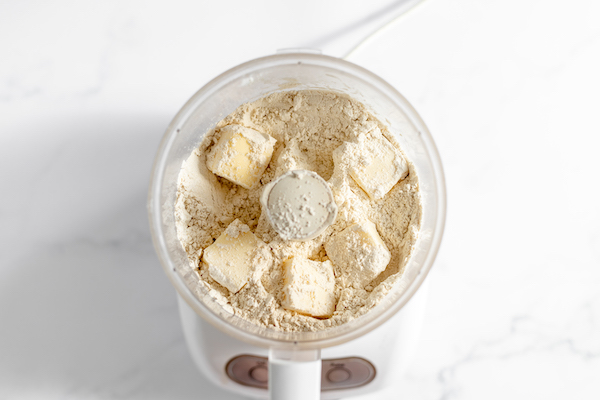 Image, taken from above shows a food processor mixing the dry ingredients for scones 