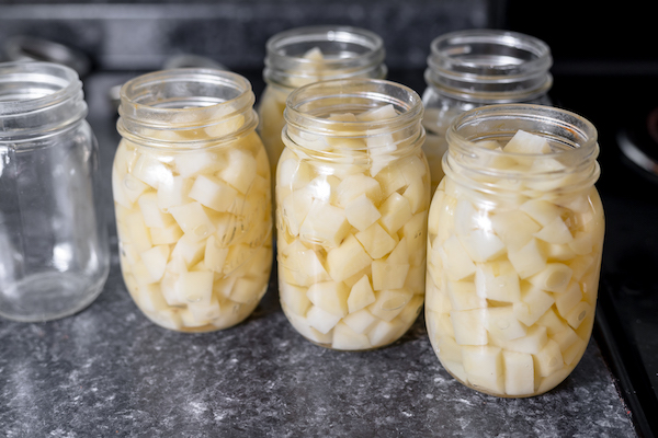 potatoes packed into canning jars