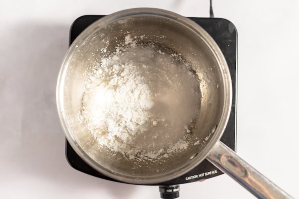 Image, taken from above, shows a pot with cornstarch and sugar in the bottom. 