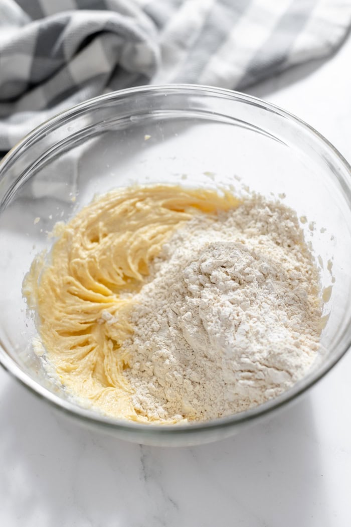 Image shows a glass bowl with batter for gluten free butter cookies, with sugar on top
