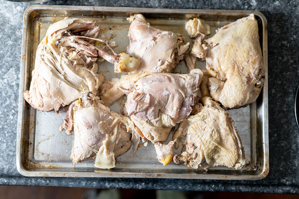 As overhead image of cooked chicken legs and thighs on a baking sheet.