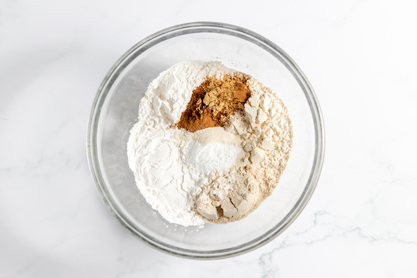Image, taken from above, shows the dry ingredients for the pumpkin muffins in a bowl, ready to be added later. 