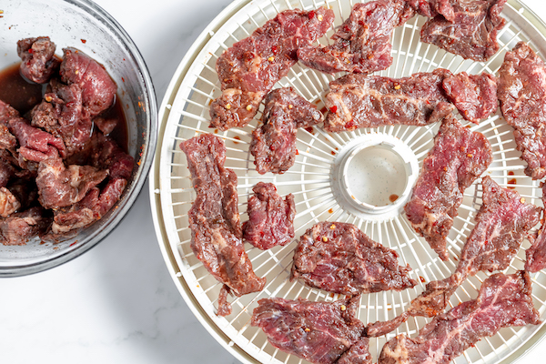 putting marinaded beef in the dehydrator