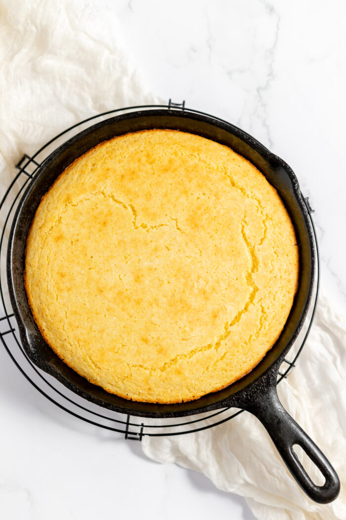 Photo, taken from above, shows fresh cornbread in an iron skillet.