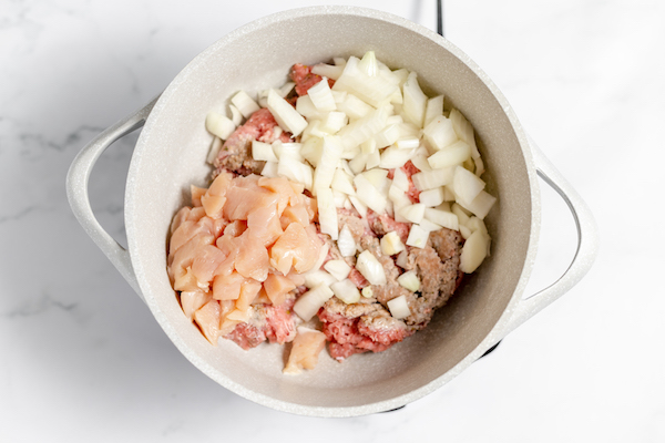 sauteing chicken, sausage, and onions in a soup kettle