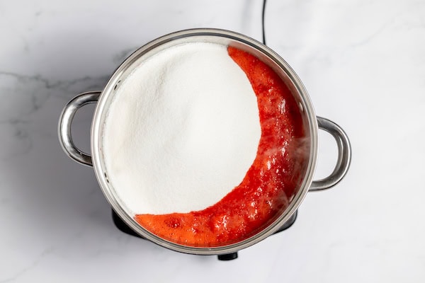sugar in the kettle of boiled crushed strawberries