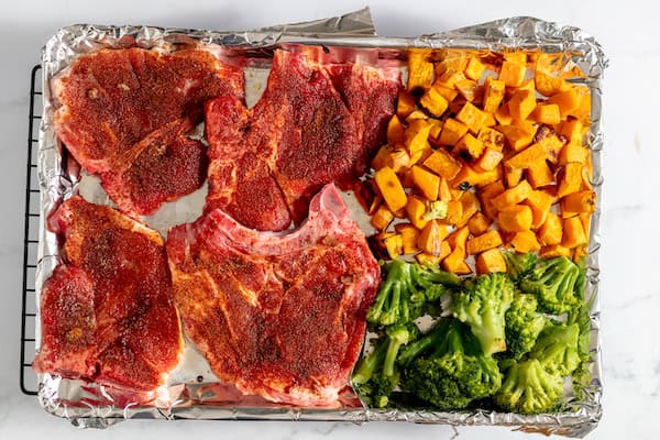 pork chops, sweet potatoes, and broccoli on a sheet pan