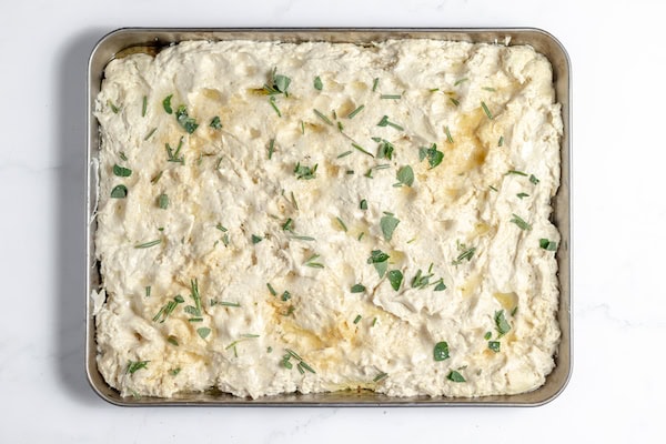 Image, taken from above, shows herbs and garlic powder sprinkled on focaccia