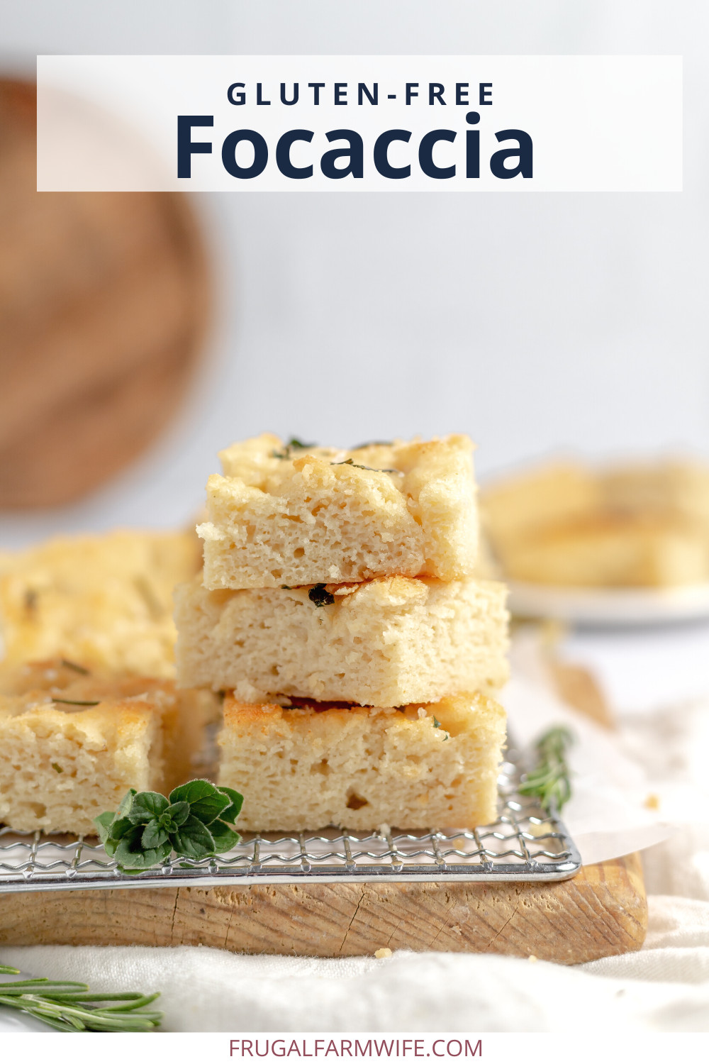 Image shows several piece of gluten free focaccia bread stacked on a wire rack. Text above reads "Gluten-free focaccia"
