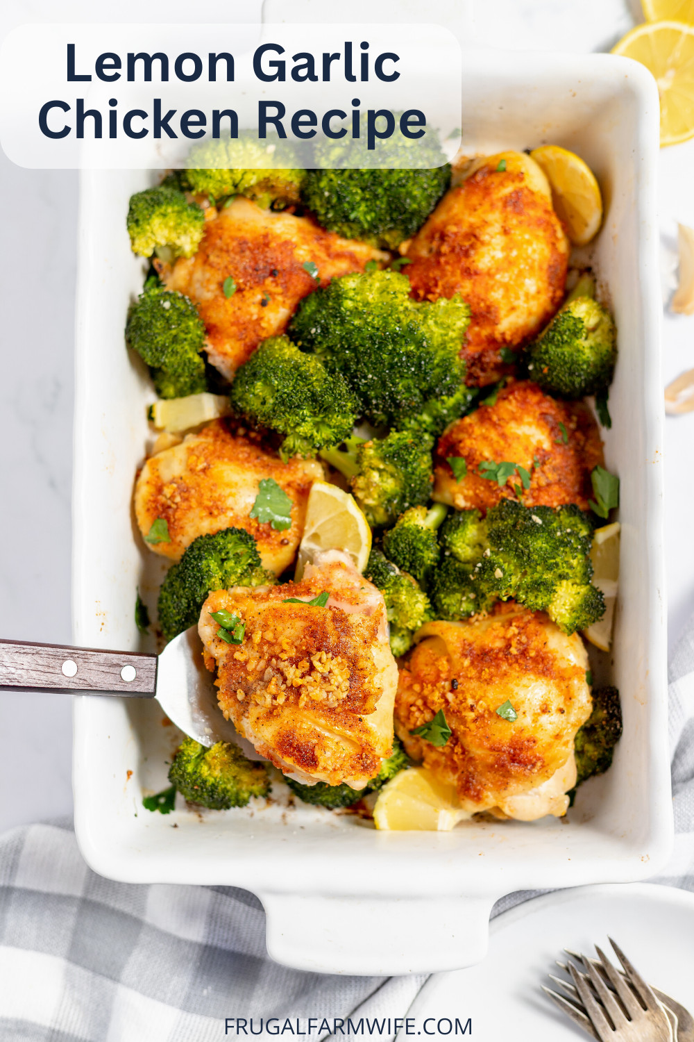 Image, taken from above, shows a white casserole dish filled with lemon garlic chicken thighs with broccoli. A spatula is scooping one chicken breast from the pan, and text above reads "Lemon Garlic Chicken Recipe"