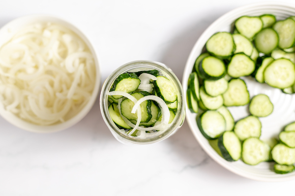 layering onions and cucumbers in a jar